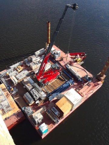 Barge delivering scaffolding to piers