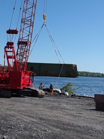 Girder being unloaded from barge