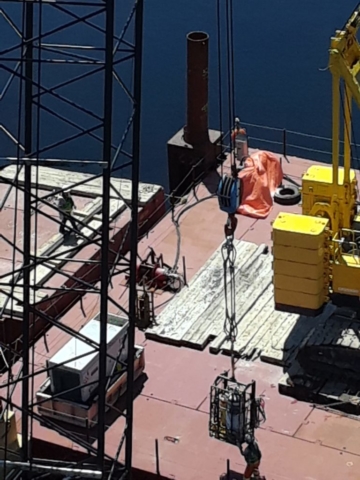 Cutting equipment being raised up to the girders from the barge