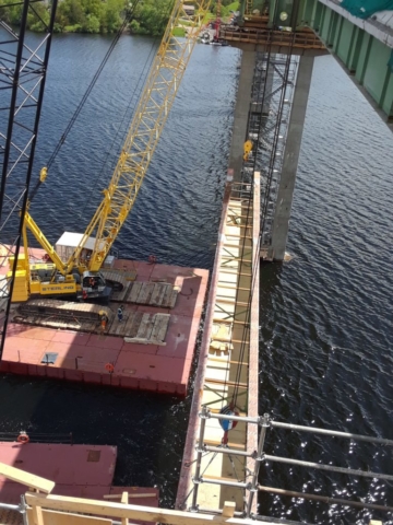 Large section of removed girder being lowered to the barges