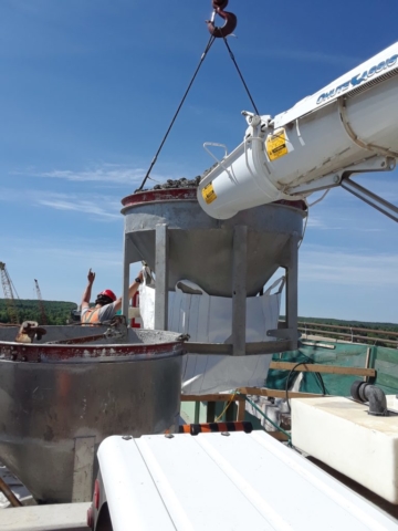 Concrete hopper filled and ready for removal by crane