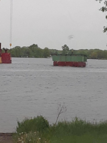 Removed piece of girder being transported to shore