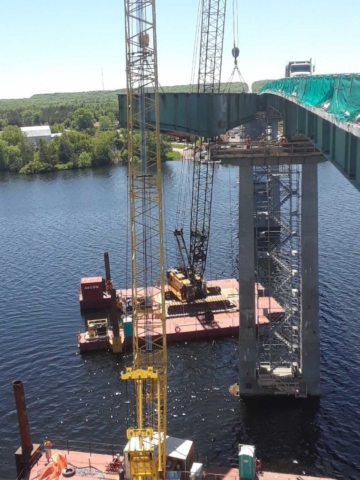 Girder being lifted from pier and lowered