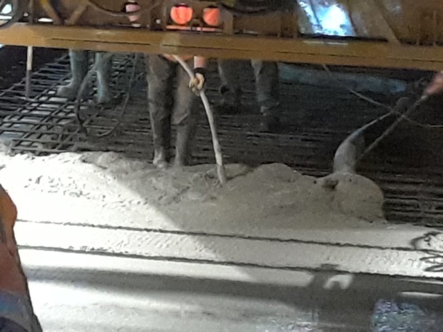 Concrete being poured from the pump