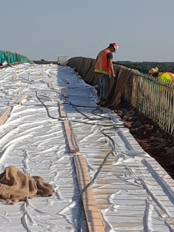 Placing burlap over rebar to keep the concrete wet