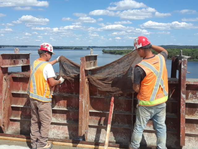 Laying the wet curing material over the freshly placed concrete