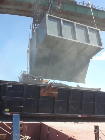 Barrier wall ruble being dumped into bins on the barge for removal