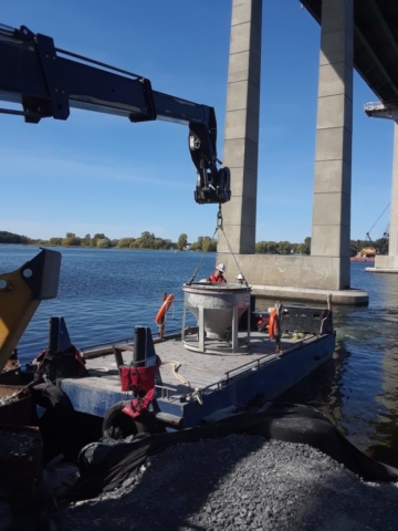 Full concrete bucket being loaded to be transported to the barge for placement