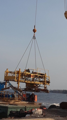 Concrete finisher being removed from the barge