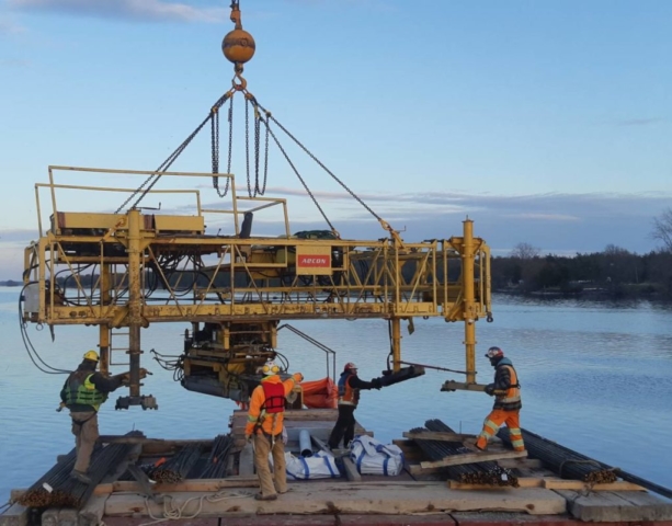 Concrete finisher being prepared to be lifted from the barge o the deck