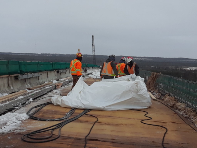 Tarping and ground heaters being removed from the deck