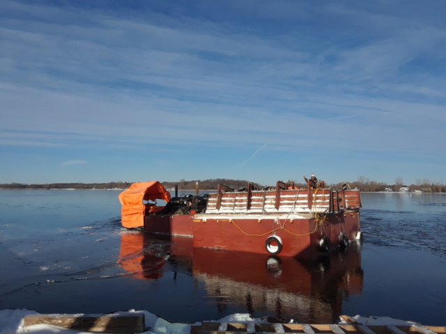 Barrier wall forms being moved by the barge to be lifted to the deck