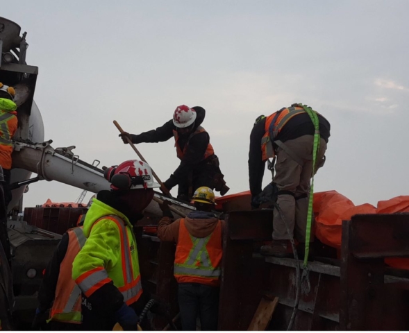 Concrete being placed into barrier wall forms