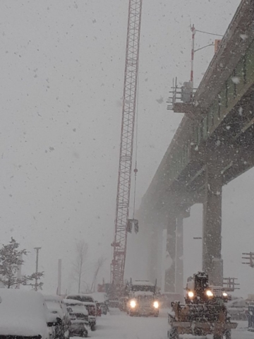 Barrier wall forms being lifted to the bridge deck by the crane