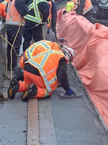 Finishing the freshly placed concrete closure strip