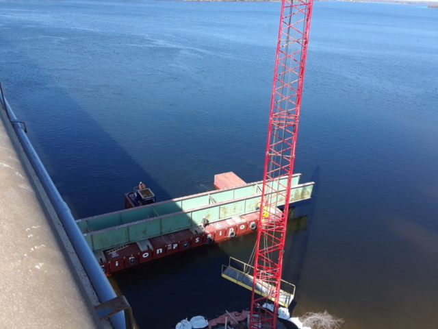 Second section of removed girder being brought to shore / crane waiting with walkway for barge access