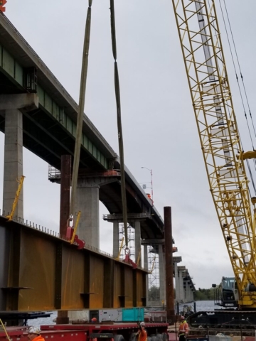 Lifting the first girder piece to the barge for assembly