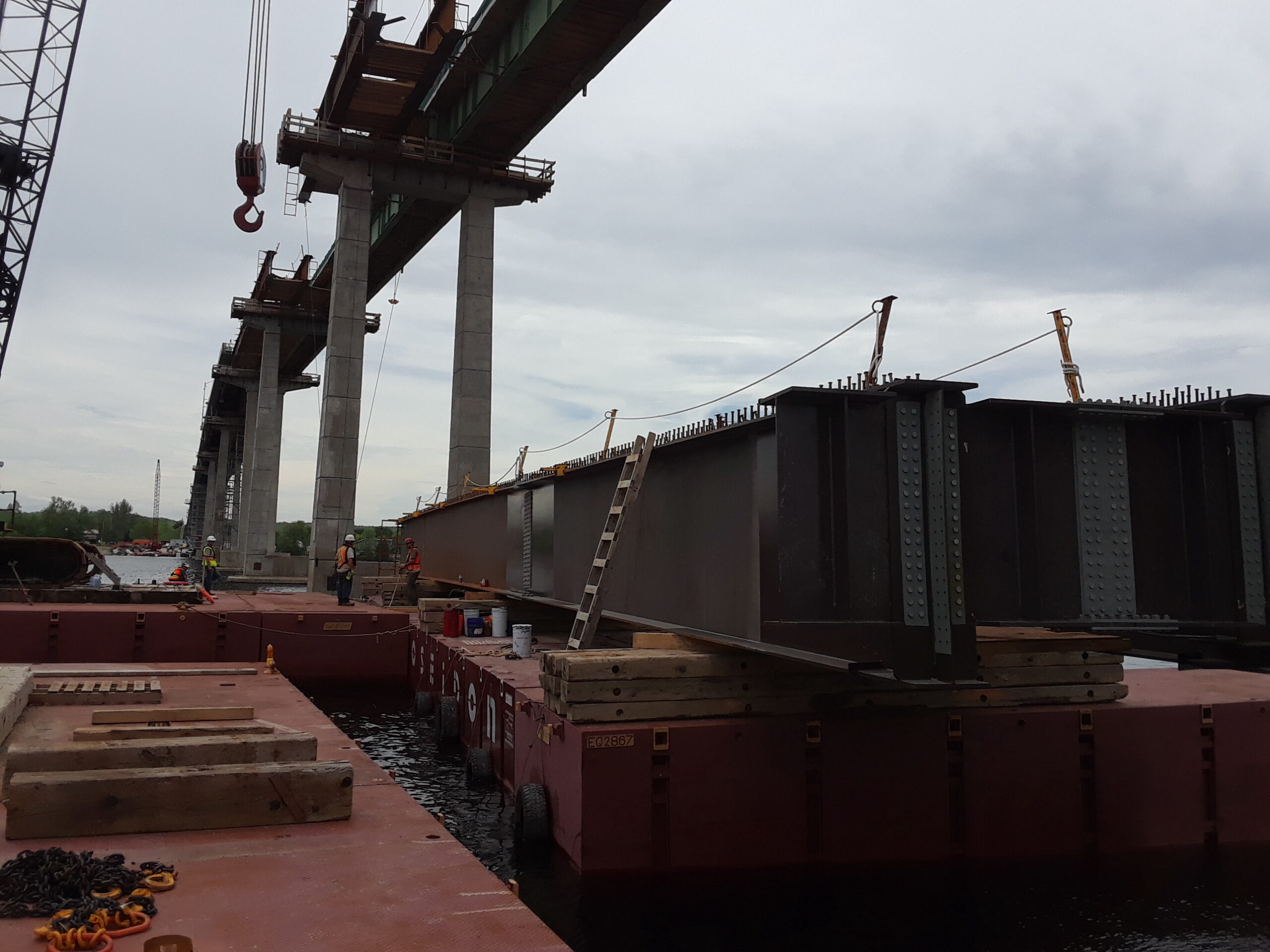 Barge with second approach girder being moved into place to be lifted