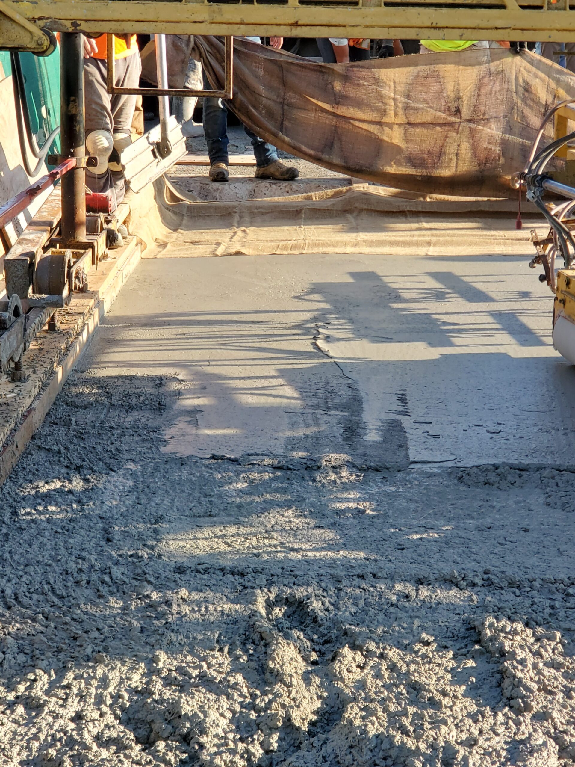 Wet burlap being placed on the fresh concrete