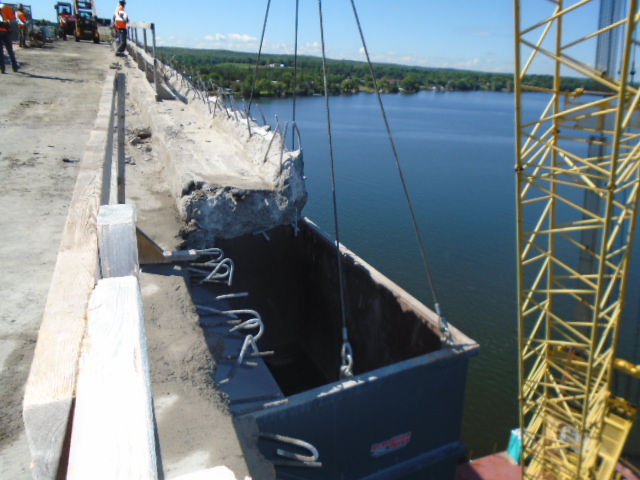 Close-up view of containment bin placed under a section of the barrier wall to be removed