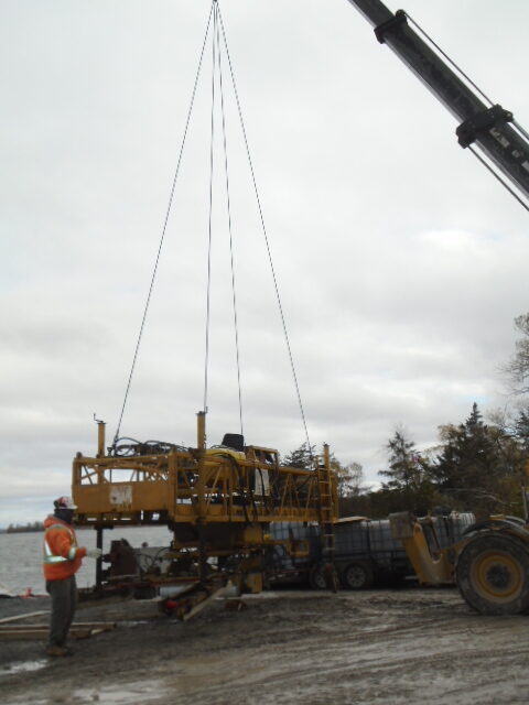 Telehandler moving the concrete finisher to the barge