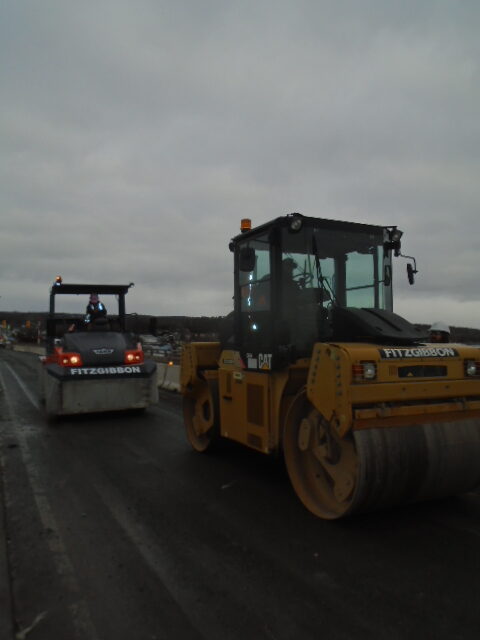 Steel drum roller and rubber tire rollers arriving on the deck for asphalt placement