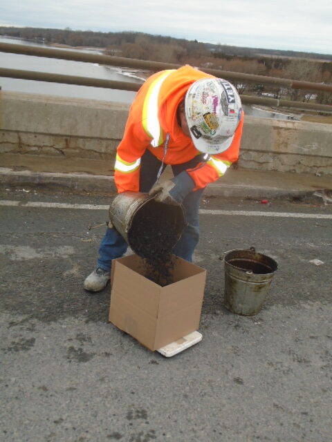 Asphalt being placed in box to be sent for testing