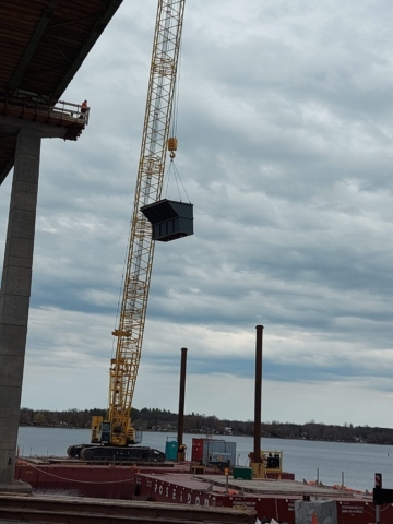 Lowering the containment bin to the barge with the 200 ton crane