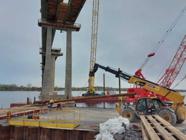 Telehandler loading spud onto the barge