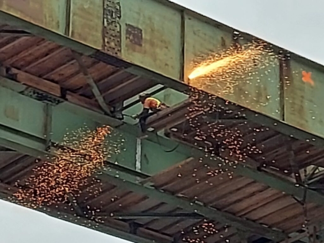 Close-up, torch cutting both sides of the girder