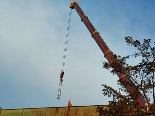 Lowering the crane cables to the approach girder between piers 13 and 14 in preparation  for girder removal