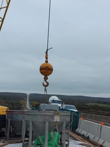 Concrete hopper hooked up to the 200 ton crane in preparation for concrete placement