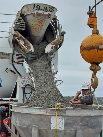 Concrete truck filling the hopper for concrete placement