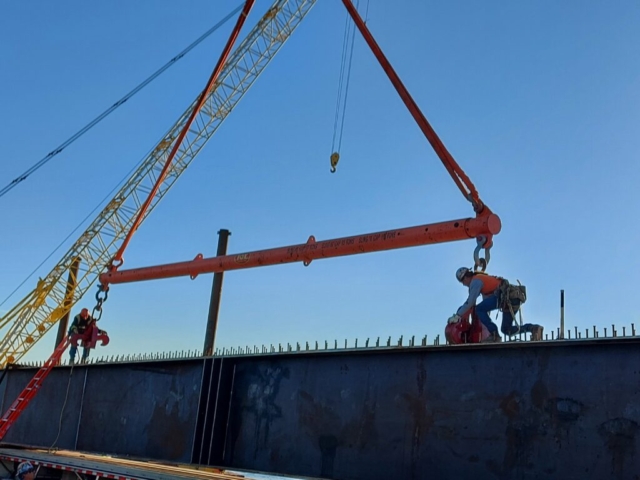 Attaching the spreader bar to the girder for removal from the truck