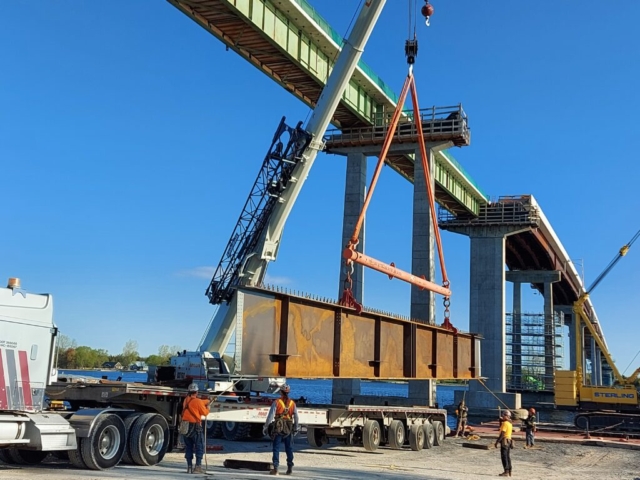 160 ton hydraulic crane starting to lift the girder piece from the truck