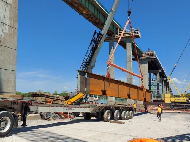 First approach girder piece being removed from the truck