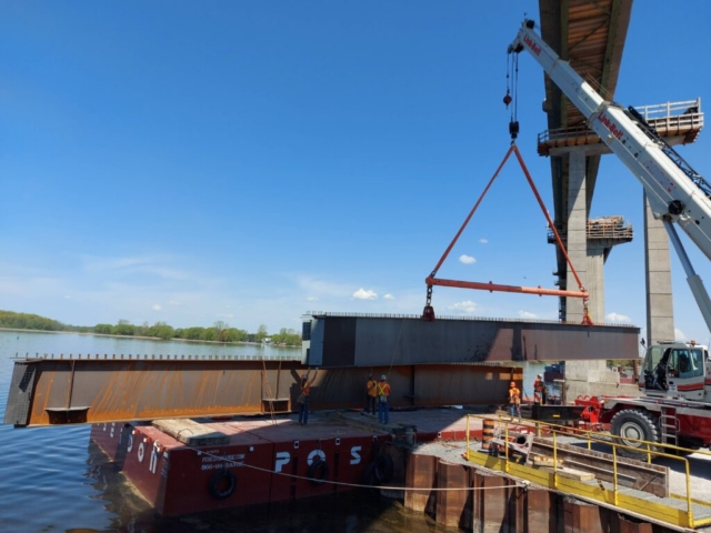 Second piece of the 1st approach girder being lowered onto the barge