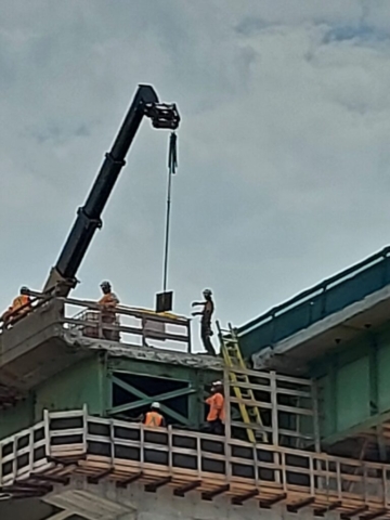 Telehandler lowering the bearing plates for installation on pier cap 14