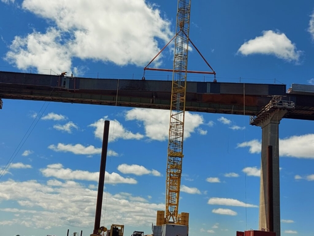 Lowering the second approach girder piece into place