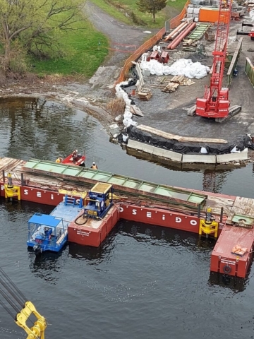 Top view of removed girder section being moved by barge to the shore