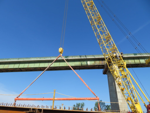 200 ton crane lifting the spreader bar to be connected to the girders