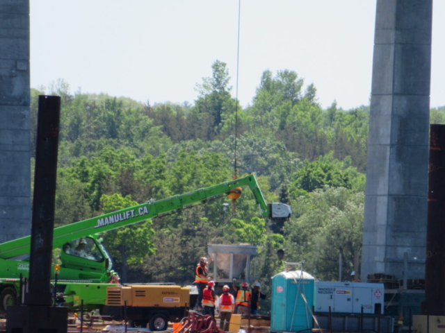 200 ton  crane lowering the concrete hopper to the concrete pump