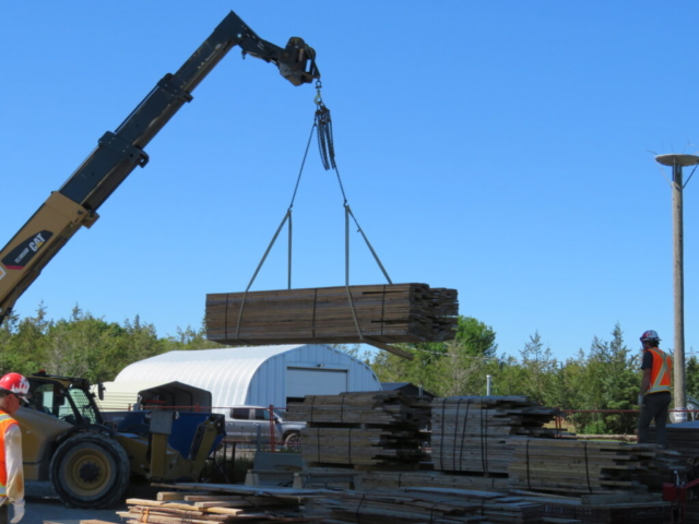 Telehandler moving the wood bundles to the crane to be lifted to the deck