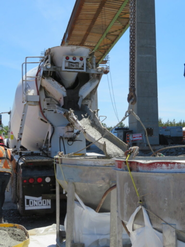 Concrete truck loading the hoppers with concrete