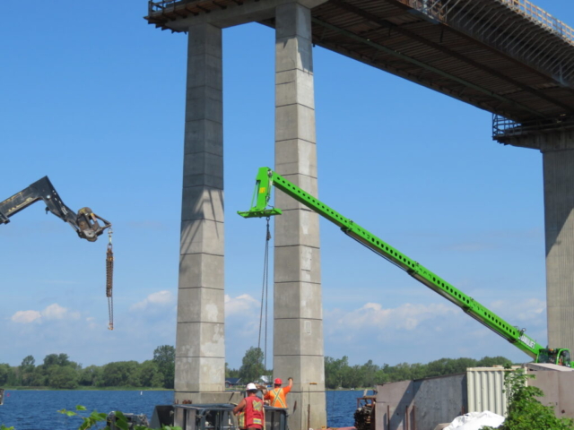 Using the man lift to move material to shore, telehandler removing material from shore area