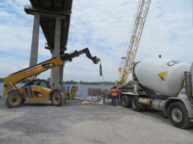 Telehandler, concrete truck and hoppers in preparation for concrete placement