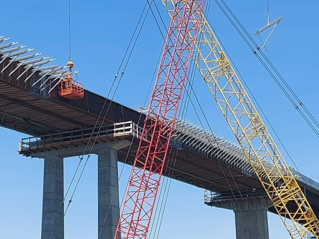 Close-up of 200 ton crane lifting the basket and 110 ton crane lifting bracket for installation