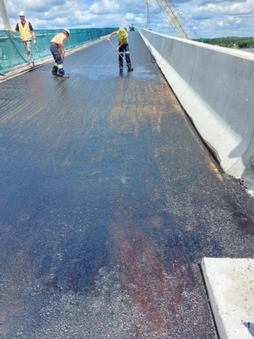 Applying tack  coat prior to the placement of the second lift of asphalt