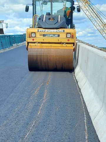 Steel drum roller on the newly placed asphalt