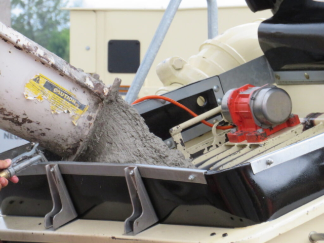 Concrete truck placing concrete into the concrete pump